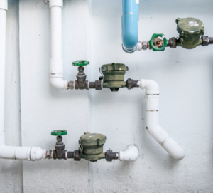 The image shows multiple water meters and associated plumbing