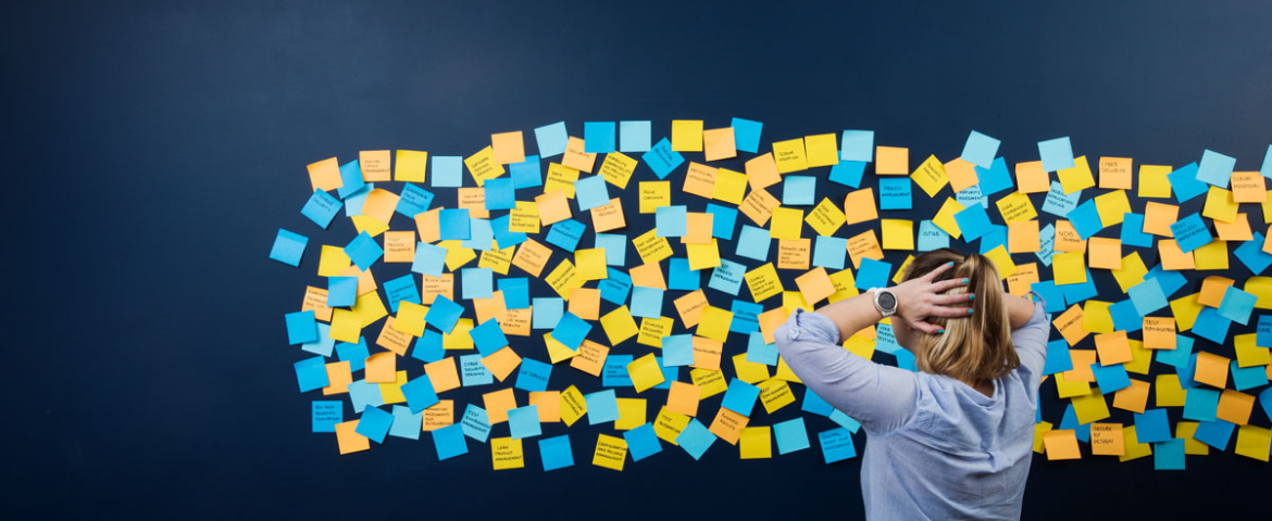 women standing infront of a wall of post its