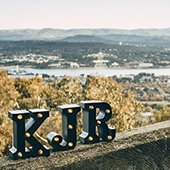 KJR logo on a cliff with a view behind