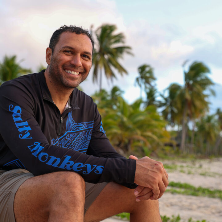 Salty Monkey team member sit next to the beach